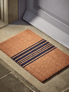 a brown door mat with blue stripes on it