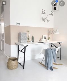 a living room with white walls and wooden accents on the wall is decorated with deer antlers