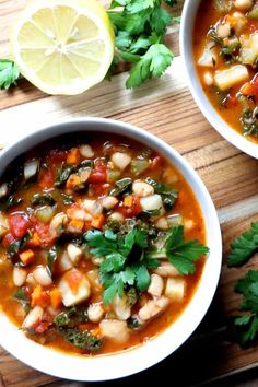 two bowls of vegetable soup on a cutting board