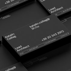 black business cards stacked on top of each other with white letters and numbers in the middle