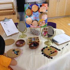 a table topped with lots of crafts and other items on top of a white table cloth