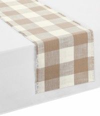 a white and brown checkered table runner on top of a bed