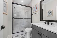 a bathroom with black and white fixtures and tile flooring, along with a walk - in shower