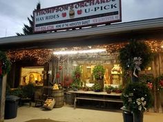 the outside of a store with christmas decorations and lights on it's front porch