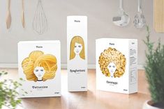 three boxes with different types of hair on top of a wooden table next to a potted plant