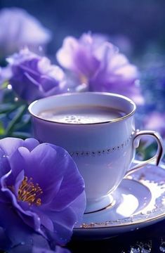 a cup of coffee and some purple flowers