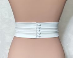 "Introducing our handmade Burgundy Bridal Belt, a stunning accessory that will add an elegant touch to your wedding dress. Made from top-quality Italian mulberry silk, this belt features a tight elastic band base for a comfortable fit. With a width ranging from 1/2\" to 3\", you can choose the perfect size to complement your gown. Fabric belts: Italy mulberry silk\\ Satin Duchess\\ Matte satin\\ Satin crepe + tight elastic band base. Length: As requested Clasp design: - minimalism. Clean smooth edge without decorative elements; - bow. Delicate silk bow; - buttons (pearl buttons, silk-covered buttons). Shine level: Matte satin - 1 points Satin Duchess - 2 points Mulberry silk - 3 points Satin crepe - 5 points The clasp design options include a minimalistic style with a clean, smooth edge, a Elegant Fitted Sashes With Matching Belt, Elegant Fitted Corset Belt With Belt Loops, Fitted Satin Bridal Belt For Bridesmaid, Fitted Satin Bridesmaid Bridal Belt, Elegant Fitted Fabric Belt, Elegant Fitted Corset Belt With Sashes, White Fitted Bridal Belt For Ceremony, Elegant Fitted Bridal Belt For Bridesmaid, Elegant Fitted White Corset Belt