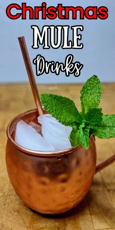 a copper cup filled with ice and mint on top of a wooden table next to the words christmas mule drinks