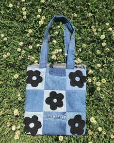 a blue bag with black flowers on it sitting in the grass