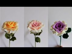 three crocheted flowers in different colors are being held by someone's hand