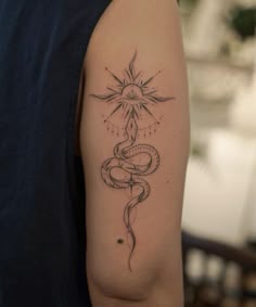 a woman's arm with a tattoo on it that has a snake and sun