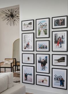 a living room with pictures on the wall and a white couch in front of it