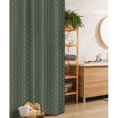 a bathroom with a green shower curtain next to a wooden dresser and toilet in front of a mirror