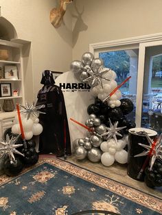 star wars themed balloons are on display in the living room with darth vader's costume