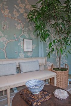 a white bench sitting next to a potted plant on top of a wooden table