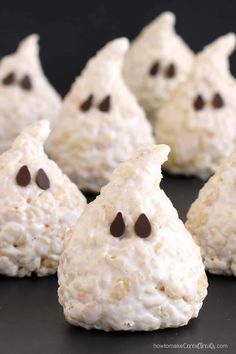 some cookies with chocolate chips in the shape of ghost faces and eyes are on a black surface