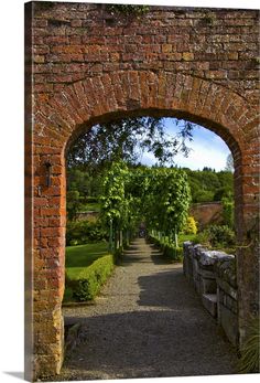 an archway leading into a lush green park