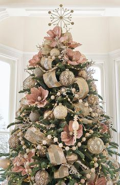 a decorated christmas tree with ornaments in the shape of balls and bells on it's top