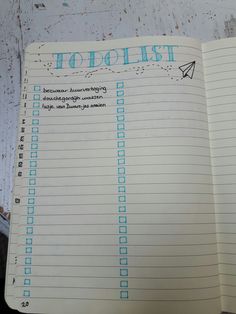 an open notebook with the words to do list written in blue ink on top of it