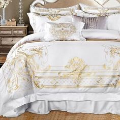 a bed with white and gold comforters in a bedroom