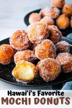 some sugared doughnuts on a black plate with the words hawaii's favorite mochi donuts