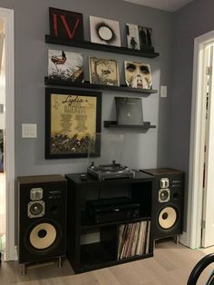 there is a record player in the corner of this room with other items on the wall