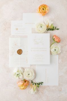 the wedding stationery is laid out with flowers