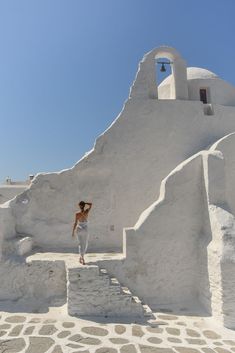 a woman standing on steps in front of a white building