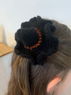 a close up of a woman's head wearing a black crochet flower