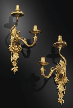 two gold - plated candelabras with candlesticks on black background