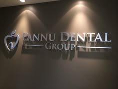 the sign for pannu dental group is lit up in front of a black wall