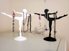 three mannequins with various jewelry hanging from them