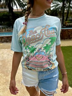 This Lotus Boyfriend Graphic Tee is the perfect laid-back look. Loose in all the right places, its open neckline and slightly dropped sleeves make it ideal for your beach days. With a Mineral Wash and a hand-drawn exclusive graphic, this tee is sure to be your new summer fave! Go get 'em, beach babe! Color: Mint or Light Pink Fabric: 100% Cotton Brand: Lotus Fashion Collection Made: El Salvador Includes: x1 Graphic T-Shirt Sizes: S-XL, Regular Sizing Retro Printed Summer T-shirt, Retro Summer T-shirt With Front Print, Casual Blue T-shirt For Beach Party, Vintage Printed T-shirt For Vacation, Blue Beach T-shirt With Front Print, Blue Sublimation Print Top For Vacation, Fun Beach T-shirt With Sublimation Print, Beach T-shirt With Sublimation Print, Retro Funny Print T-shirt For Beach