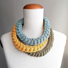 multicolored knitted necklace on mannequin neck with wooden bead closure