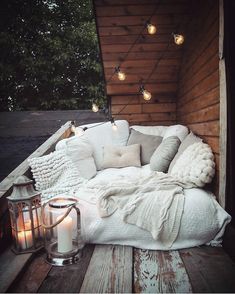 a white couch sitting on top of a wooden floor next to a light filled wall