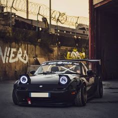 a black sports car parked in front of a building