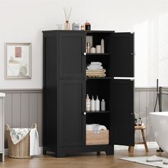 a bathroom with a black cabinet next to a bath tub