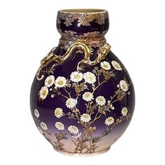 a purple vase with white flowers and a gold dragon on the top is sitting in front of a white background