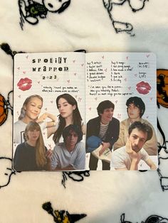 an open book with pictures of people and butterflies on the cover, sitting on a bed