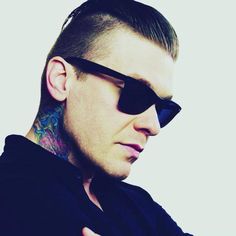 a man with tattoos on his arm wearing sunglasses