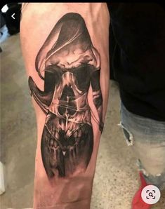 a man's arm with a skull and hat tattoo on the left side of his leg