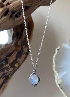 Classic handmade silver necklace with a large high quality beautiful rainbow moonstone that is known to be a stone of love that provides calmness & protection.  This is a simple but stunning necklace that has beautiful curved detailing around the edge.  I handpick all the moonstone stones and no two are identical as they are all natural stones. The moonstones vary in colour and some are more milky than others and some are more transparent with flashes of blue/ the spectrum. If you have a specific requirement please message me as I can see what stones I have in stock and can handpick one just for you.  This necklace is a classic vintage everyday piece that is very wearable and it makes a beautiful simple statement as well as being a pretty piece of jewellery to dress an outfit up. The neckl White Moonstone Moon Phase Necklace, White Moonstone Crystal Necklace With Moon Charm, Handmade Silver Moonstone Crystal Necklace, Mystical Silver Moonstone Necklace, Handmade Dainty Moonstone Necklace, Dainty Handmade Moonstone Necklace, Mystical White Moonstone Necklaces, Bohemian Round Moonstone Necklaces, Bohemian Moonstone Birthstone Necklace