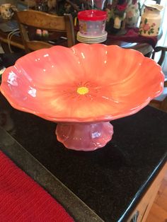 an orange flower shaped dish on a black countertop in a room with other items