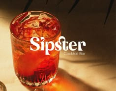 a close up of a drink in a glass with the word sipster on it