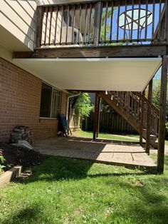 an outside view of a house with a deck and stairs leading up to the second floor