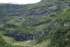 the mountains are covered in lush green grass