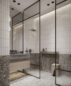 the bathroom is decorated in white and grey tones with glass partitions to divide it from the rest of the room