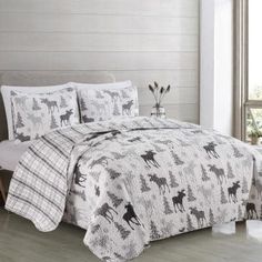 a bed with white sheets and black horses on it