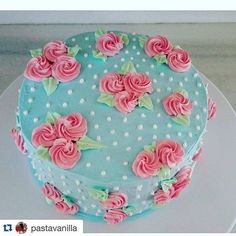 a blue cake with pink flowers on it