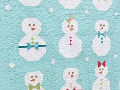 a quilted wall hanging with snowmen on it